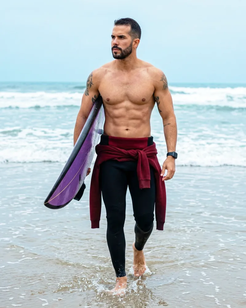 Estudo com IA: homem caminhando na praia com prancha de surfe